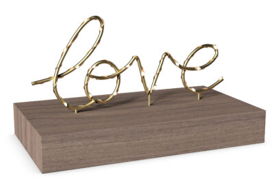 Wire sign that says "love" in script, wrapped in fairy lights on a wooden base